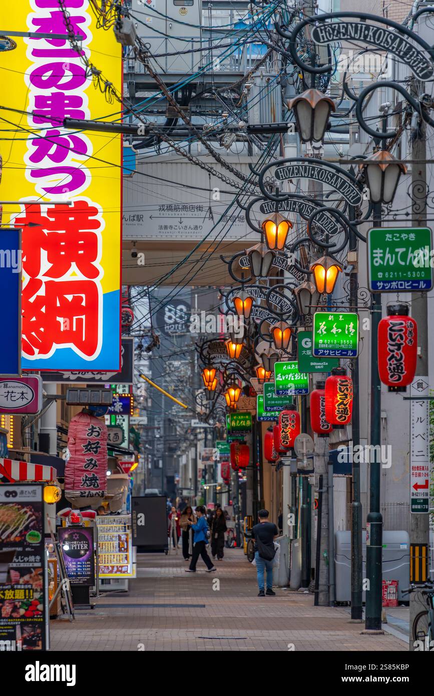 Vista dei cartelli colorati nella via secondaria di Dotonbori, vivace quartiere dei divertimenti vicino al fiume, Osaka, Honshu, Giappone Foto Stock