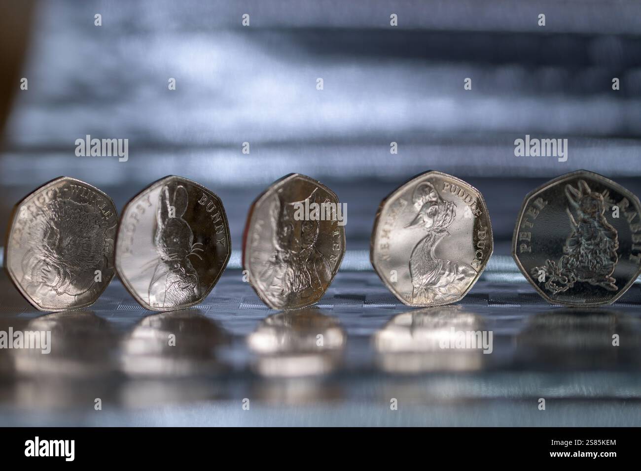 Sterling Coins, set Beatrix Potter da 50p, monete da 50 pence, posizionate su una superficie riflettente Foto Stock