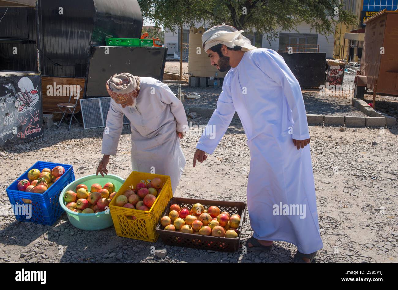 Uomo che vende melograni (frutta) ai margini della strada, Sultanato dell'Oman, Penisola Araba Foto Stock
