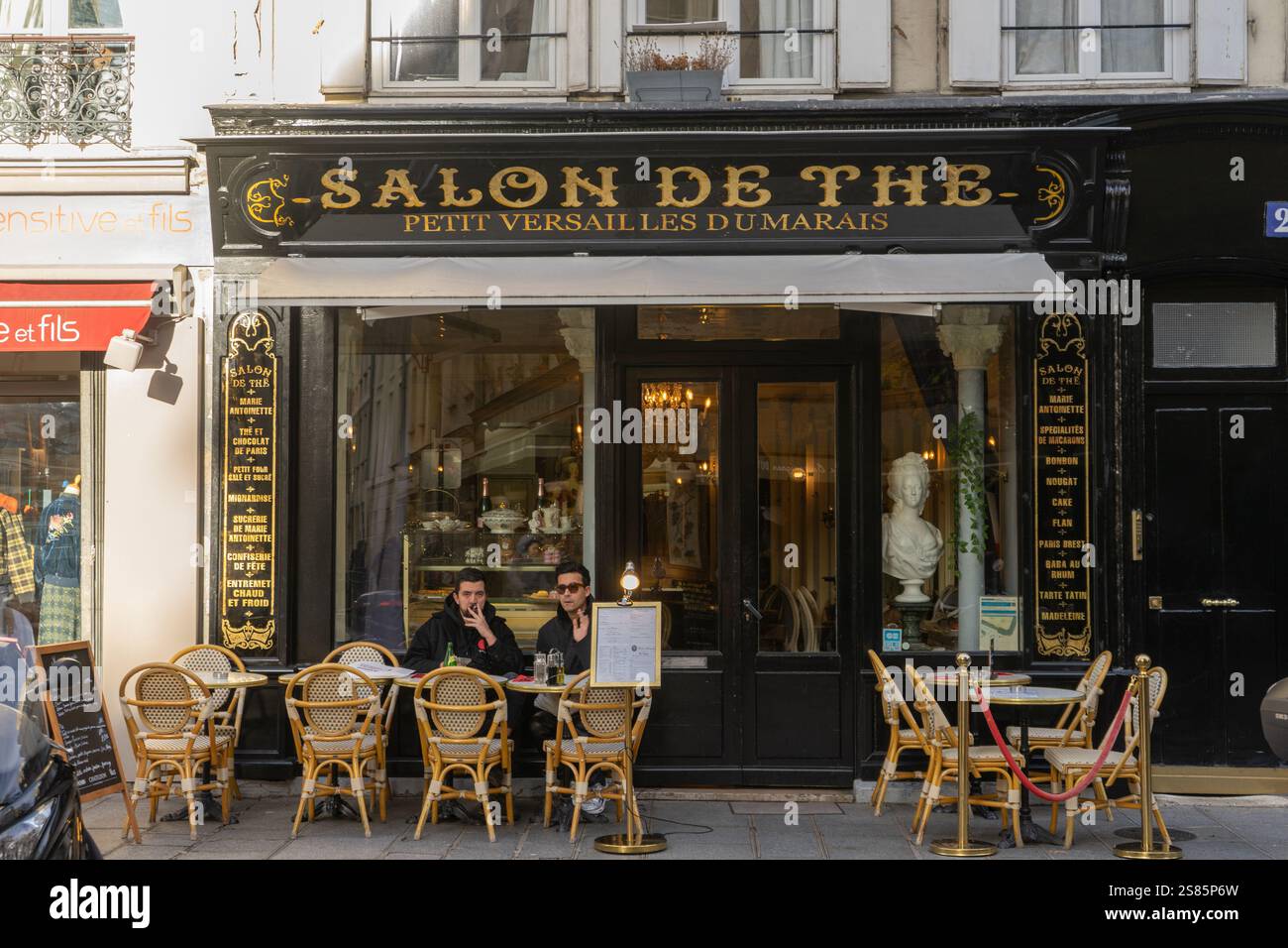 Due uomini sulla terrazza della sala da tè Salon de the in Rue Francois Miron, Parigi, Francia Foto Stock