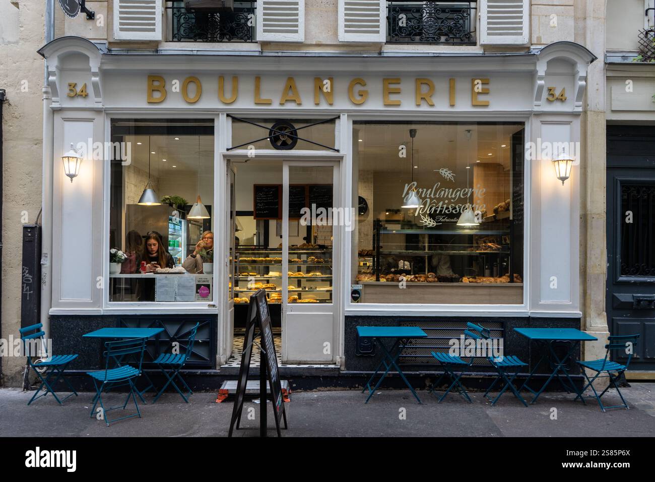 Due donne bevono caffè in vetrina di boulangerie nel Marais, Parigi, Francia Foto Stock