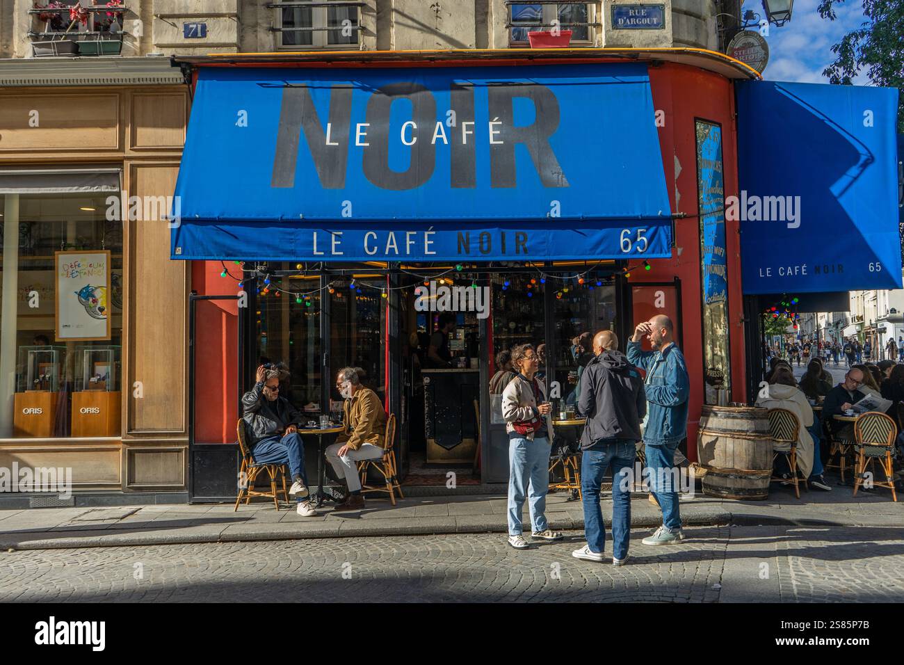 Bevitori fuori le Cafe Noir in Rue Montmartre in un pomeriggio di sole, Parigi, Francia Foto Stock