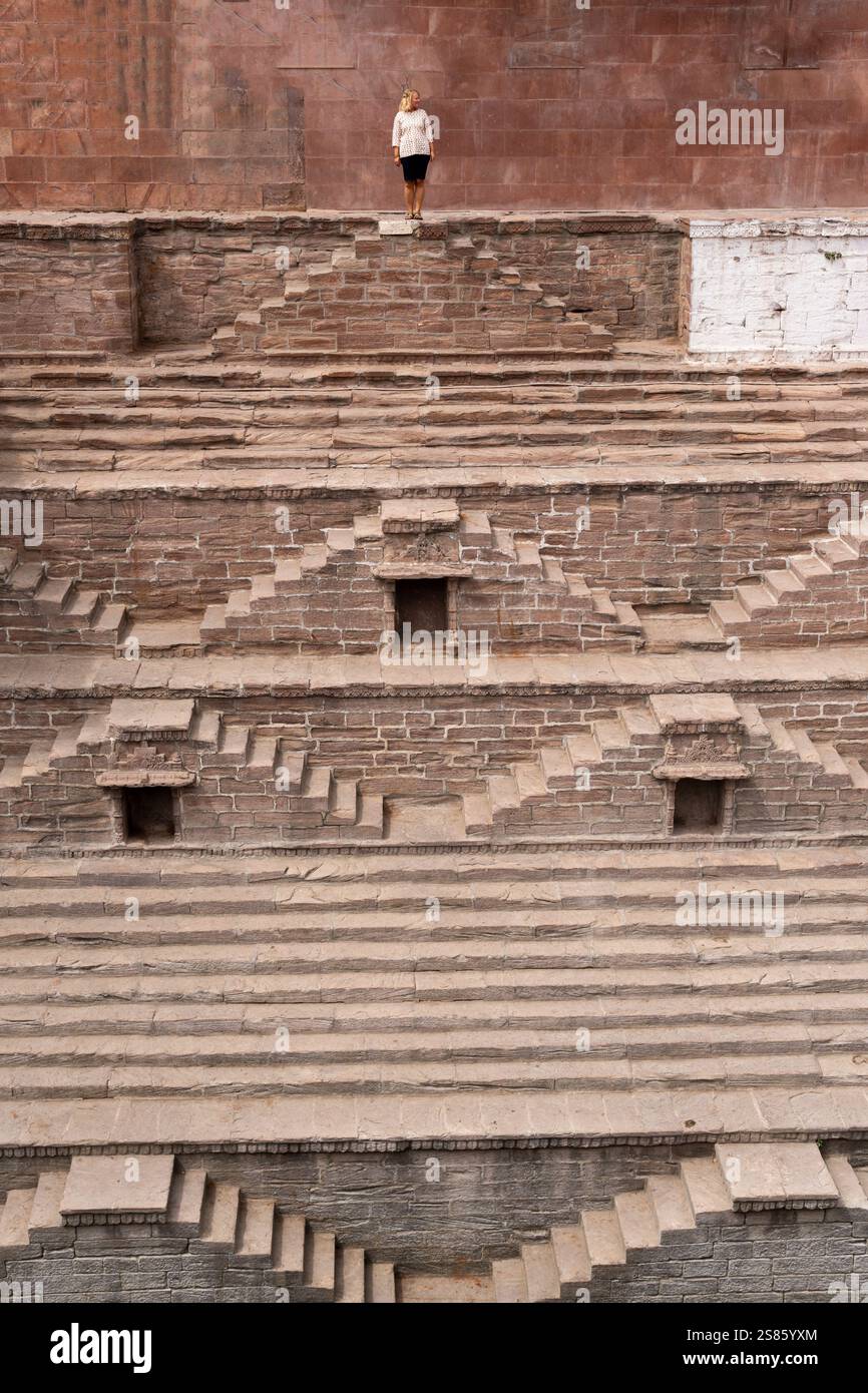 Donna bionda in cima all'antico gradino di Jodhpur, India. Architettura tradizionale Rajasthani. Foto Stock