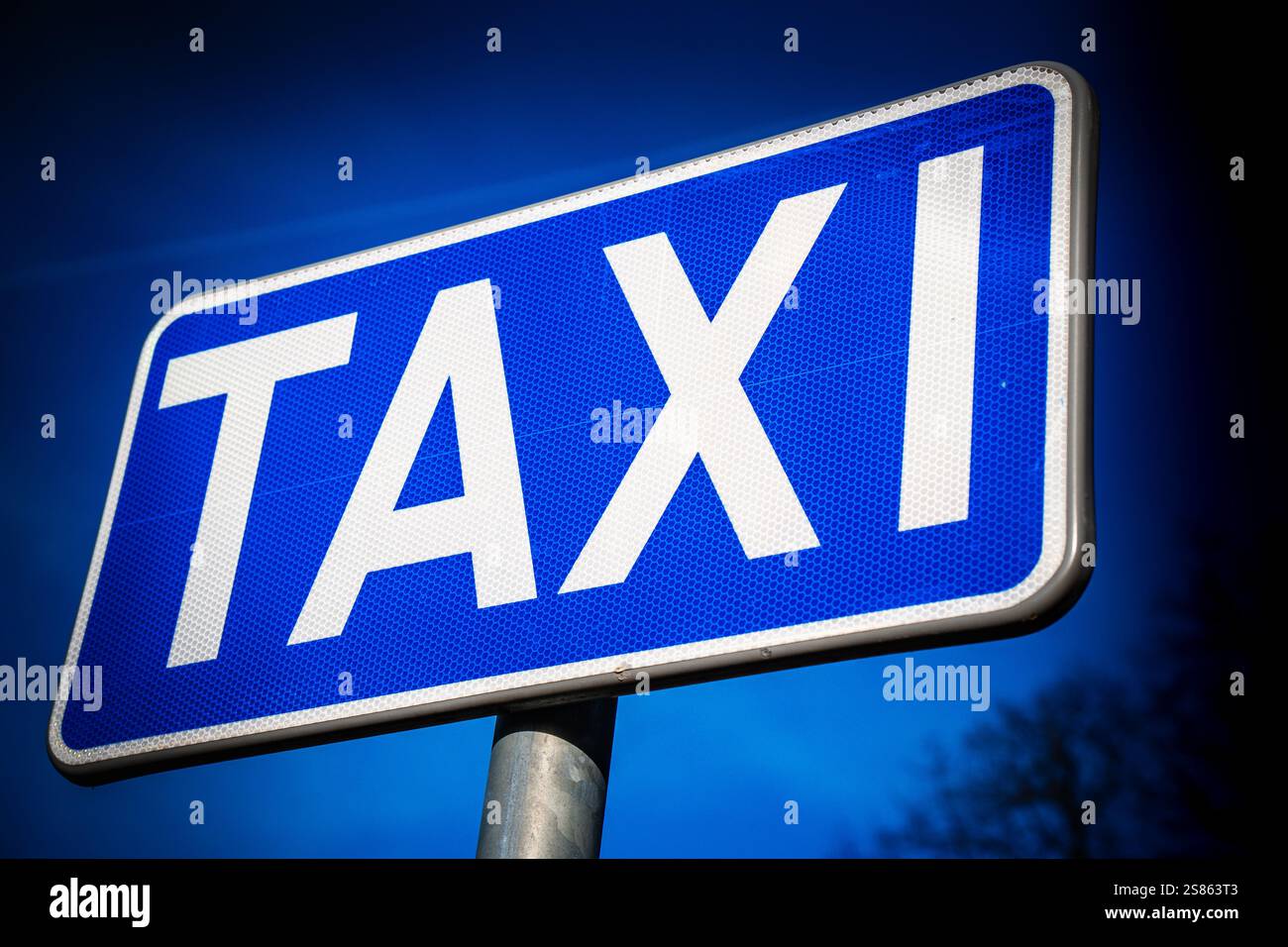 Cartello dei taxi contro un cielo azzurro in un'area urbana trafficata che segnala la disponibilità del servizio di trasporto Foto Stock