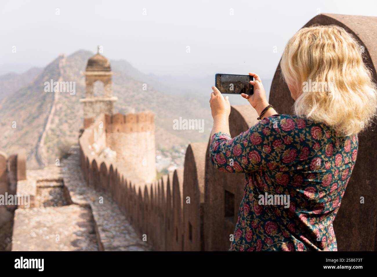 Giovane donna bionda che si fa selfie sulla grande parete di Jaipur nel Rajasthan. Felice sorridente turista europeo che esplora l'India. Foto Stock