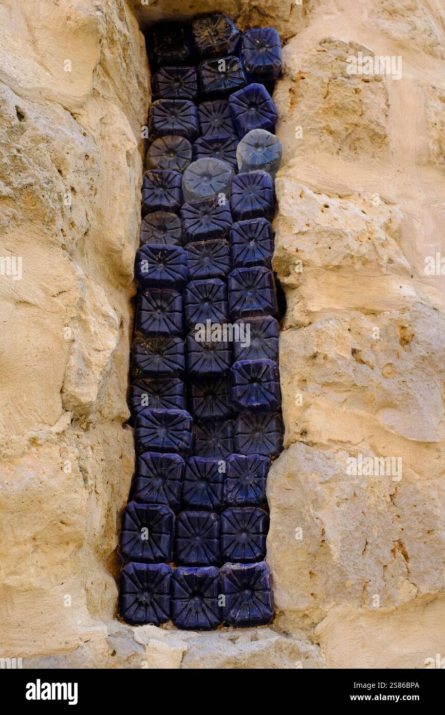 Tradizionale finestra allungata riempita con estremità in plastica per bottiglie. Monzón de Campos, Castiglia y Leon, Spagna Foto Stock