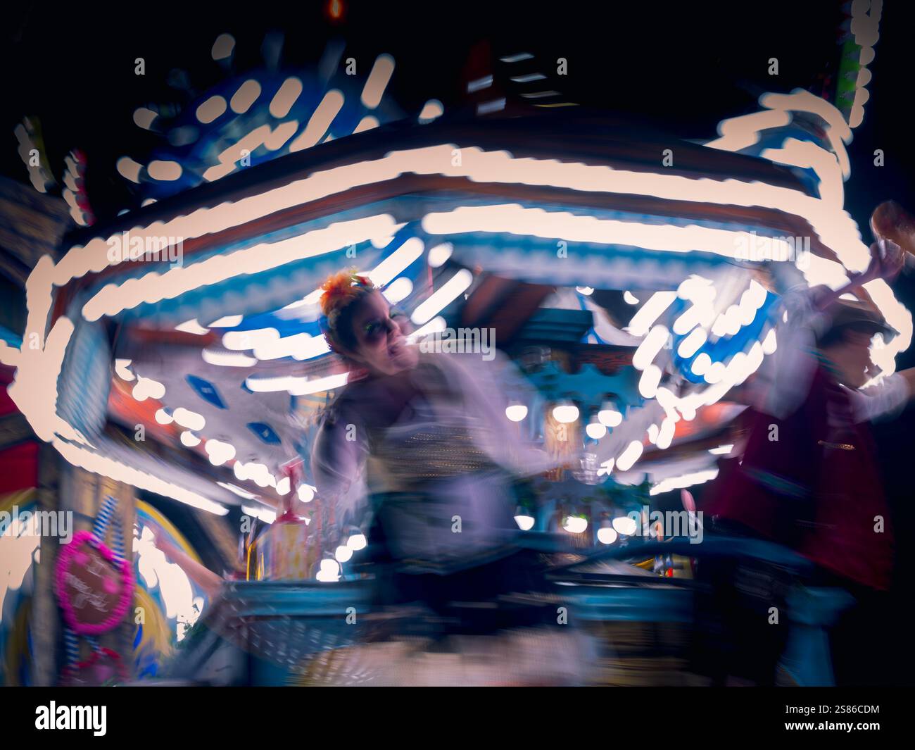 Il Carnevale di Glastonbury danza su un galleggiante che si muove rapidamente creando una sfocatura Foto Stock