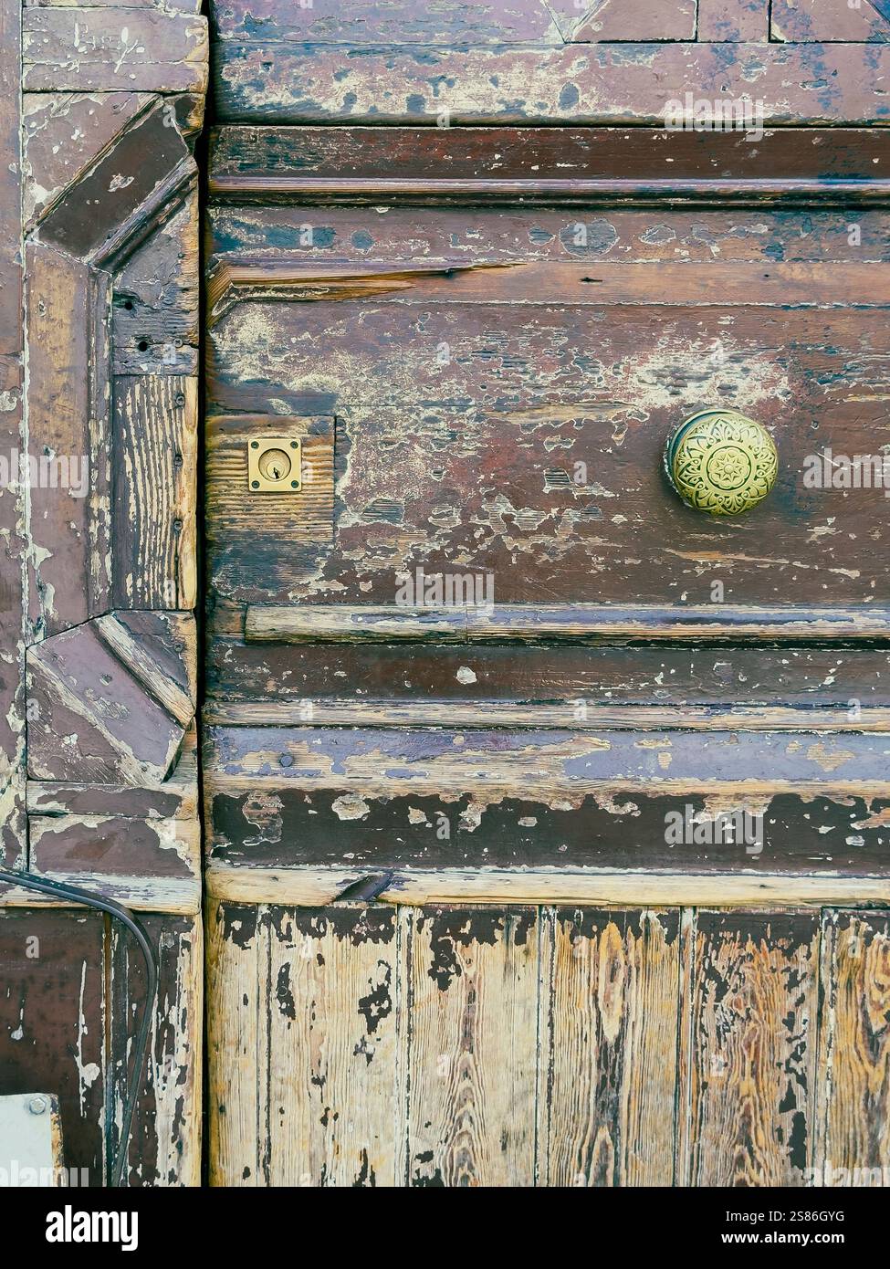 Nel cuore di Napoli, in Piazza Garibaldi, una porta in legno d'epoca è una silenziosa testimonianza dei ritmi sempre mutevoli della città. Foto Stock