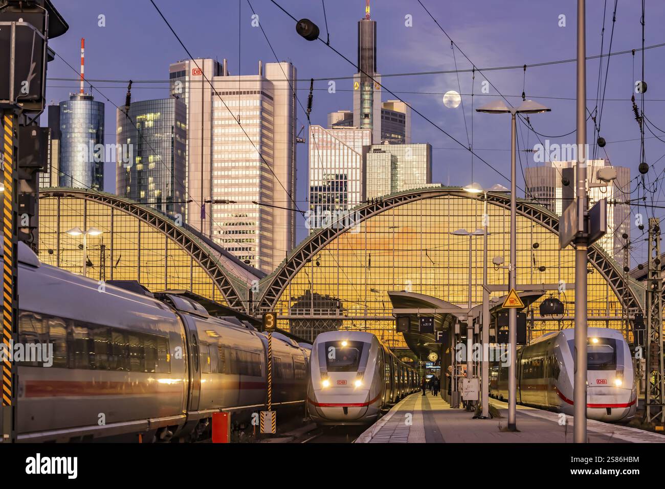 Stazione centrale di Francoforte con treno ICE in serata, luna piena e tramonto. Vista della piattaforma e del quartiere bancario, skyline di Francoforte sul meno, Assia Foto Stock