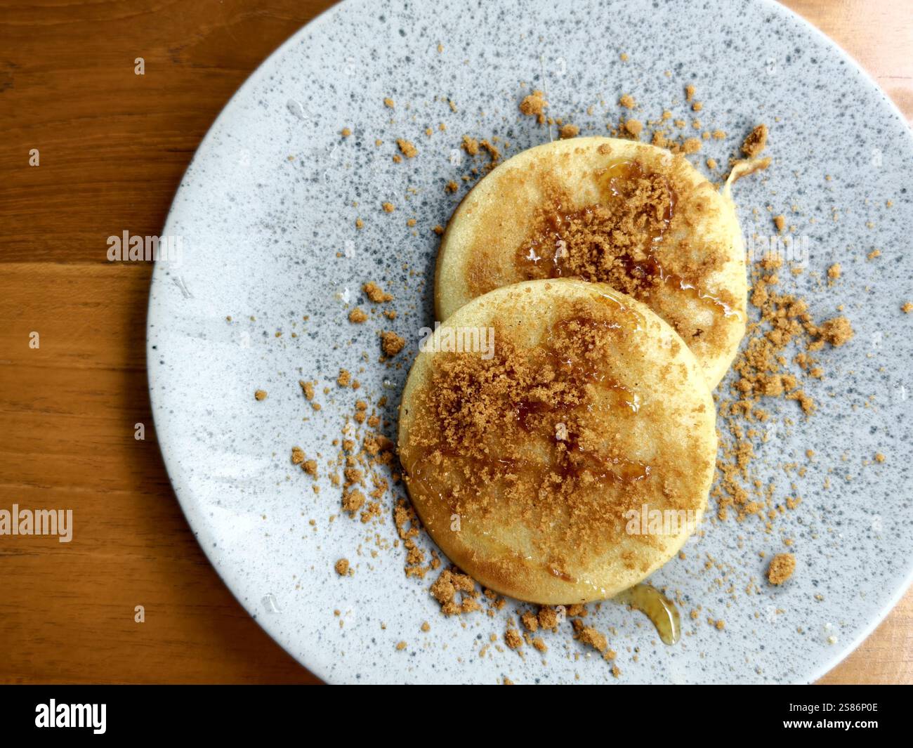 Un piatto di pancake fatti in casa con condimenti di briciole di zucchero di canna e miele Foto Stock