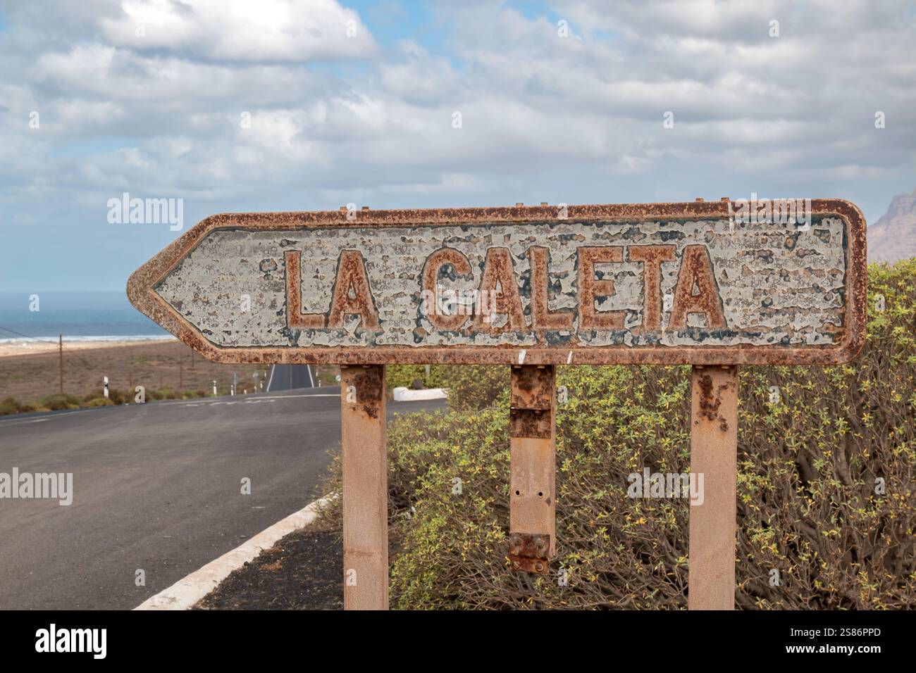 Indicazioni stradali per un villaggio di la Caleta. Vicino all'oceano Atlantico, arrugginito a causa del vento salato. Lanzarote, Isole Canarie, Spagna. Foto Stock