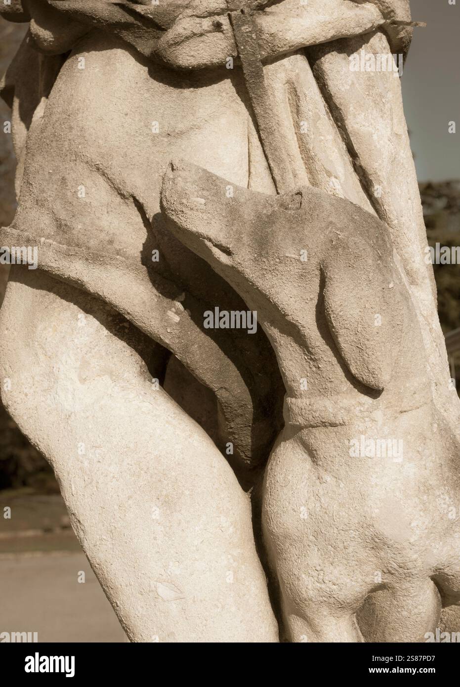 dettaglio di una vecchia statua classica con cane in un parco Foto Stock