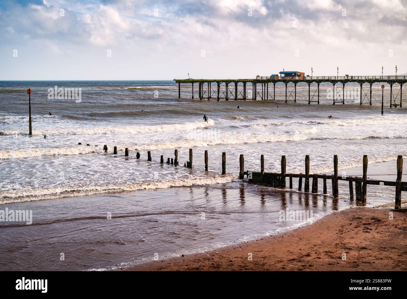 Ottobre surfisti alla spiaggia di Teignmouth e al Grand Pier, visti dalla Promenade, Teignmouth, Devon, Inghilterra, Regno Unito. Foto Stock