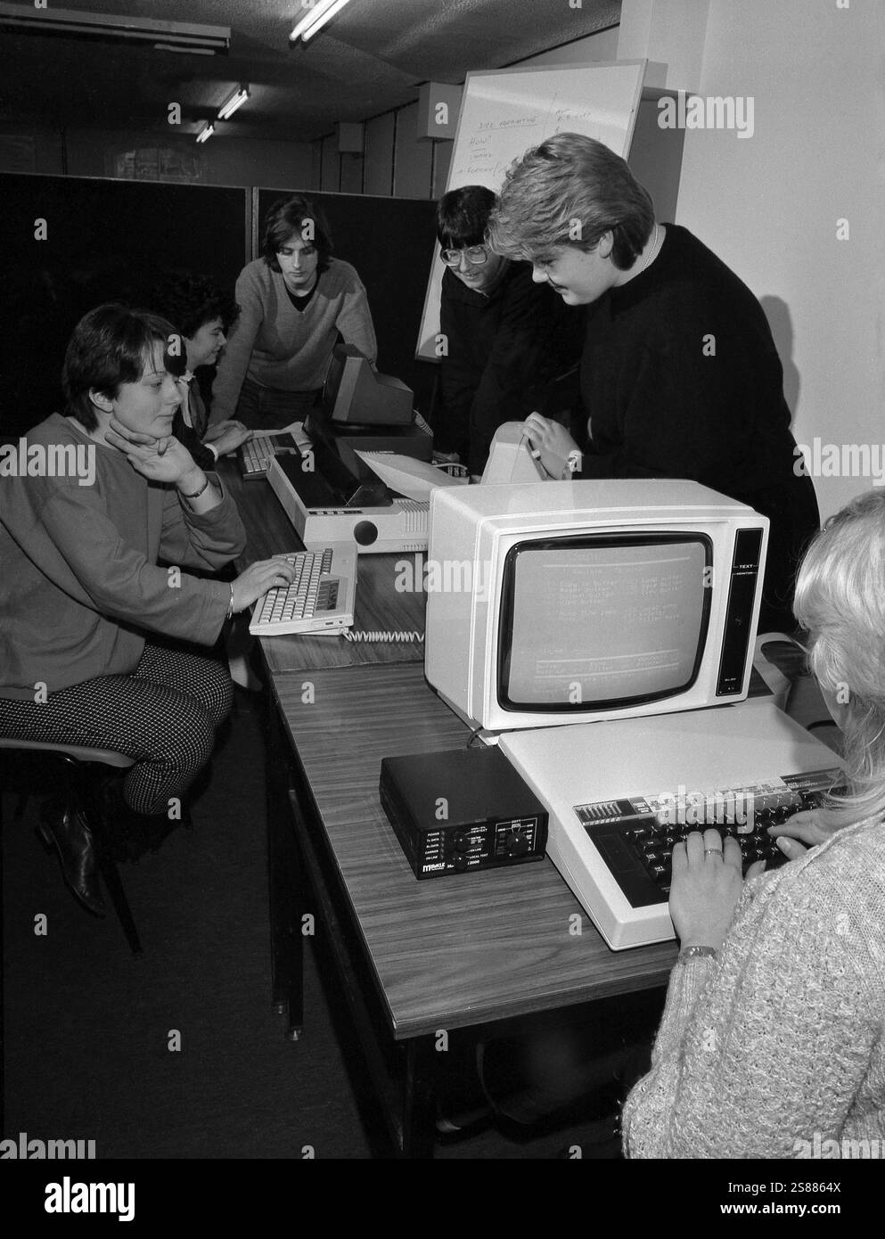 1985, durante un corso di formazione informatica, una donna che utilizza un terminale di computer dell'epoca, seduta a digitare su una tastiera di Pace Micro Computers. Accanto al monitor, è presente un modem blackbox di Miracle Technology, un modem WS2000, che all'epoca consentiva a un computer di connettersi alla rete telefonica BT. Foto Stock