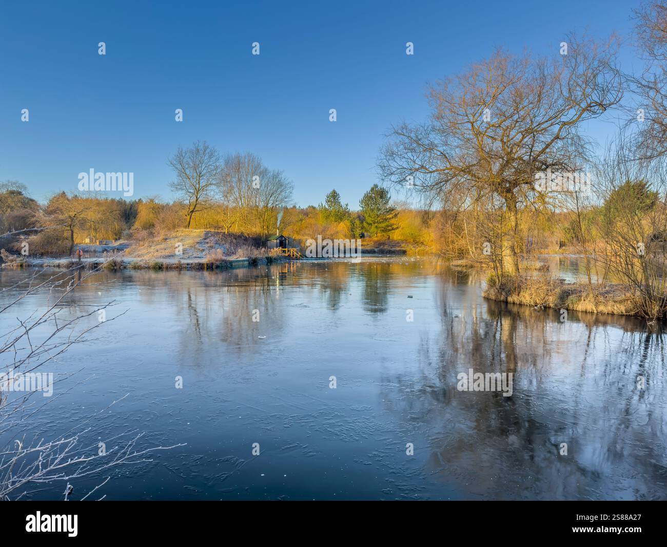 L'inverno presso la Pool Bridge Farm rivela un laghetto ghiacciato, creando un ambiente sereno per gli appassionati di nuoto all'aperto nel clima freddo dello Yorkshire. Foto Stock