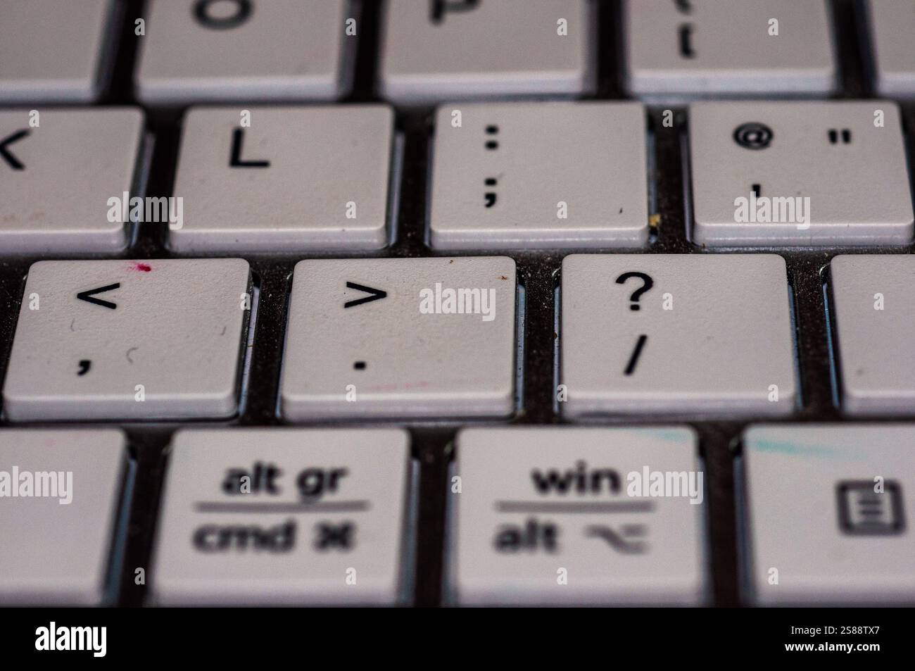 Primo piano della tastiera di un computer. L'immagine mostra i tasti, inclusi i tasti '', '?' e '/', insieme ad altri tasti come 'alt gr', 'cmd x', 'win', Foto Stock