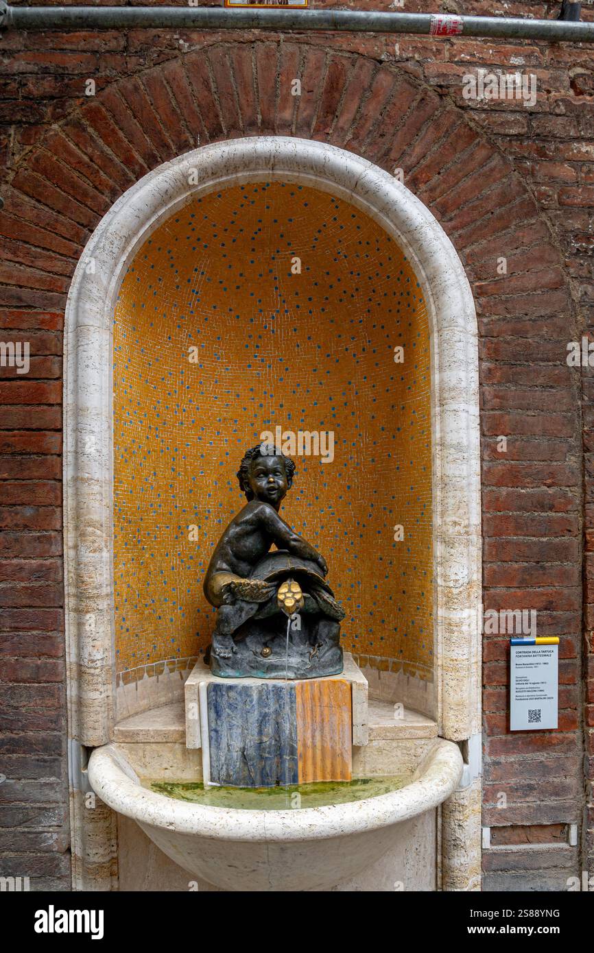 La fontana della Tartuca , Fontana della Tartaruga, incastonata in una cinta muraria su via San Pietro nelle Contrade della Tartuca a Siena, Italia Foto Stock