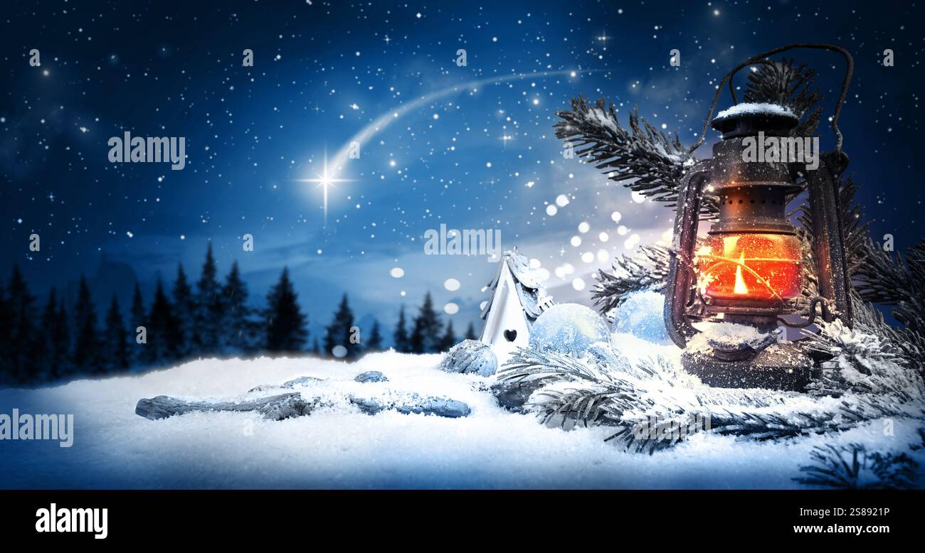 Il bagliore natalizio scintilla la stella della lanterna con la candela nella notte Santa in inverno con il paesaggio dei fiocchi con la stella di Betlemme e Natale. Foto Stock