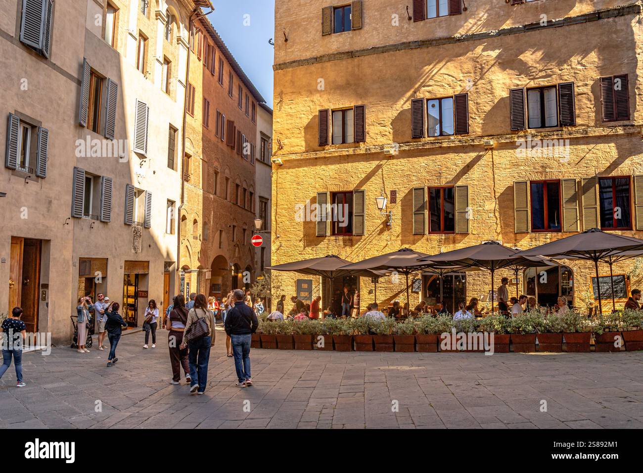 Si passeggia per Piazza San Giovanni nella città medievale di Siena Foto Stock