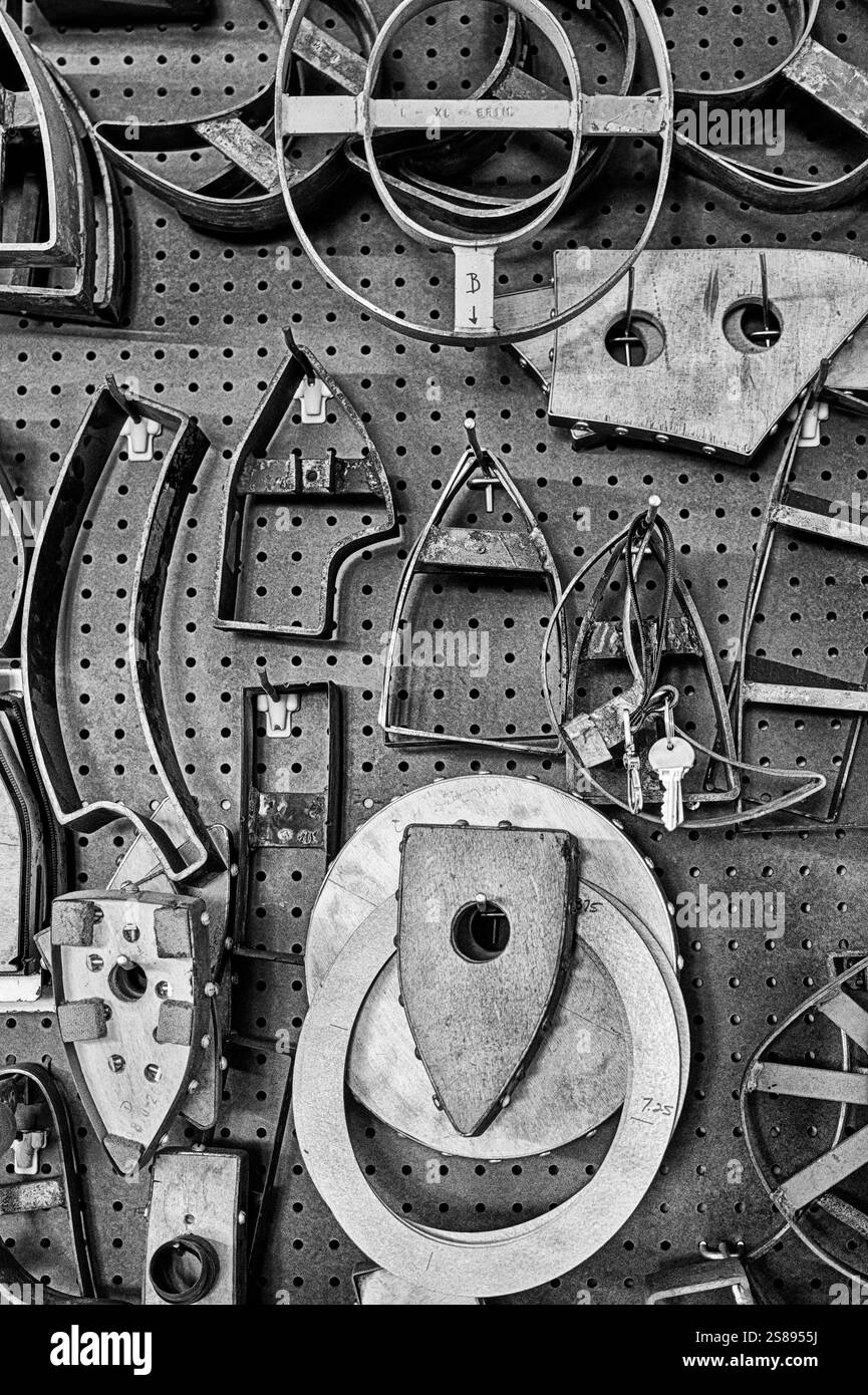 LOS ANGELES, CA - 31 LUGLIO 2024: Una parete in pegboard in una sala di lavoro della fabbrica è piena di strumenti e forme che vengono utilizzati per creare cappelli. In bianco e nero. Foto Stock