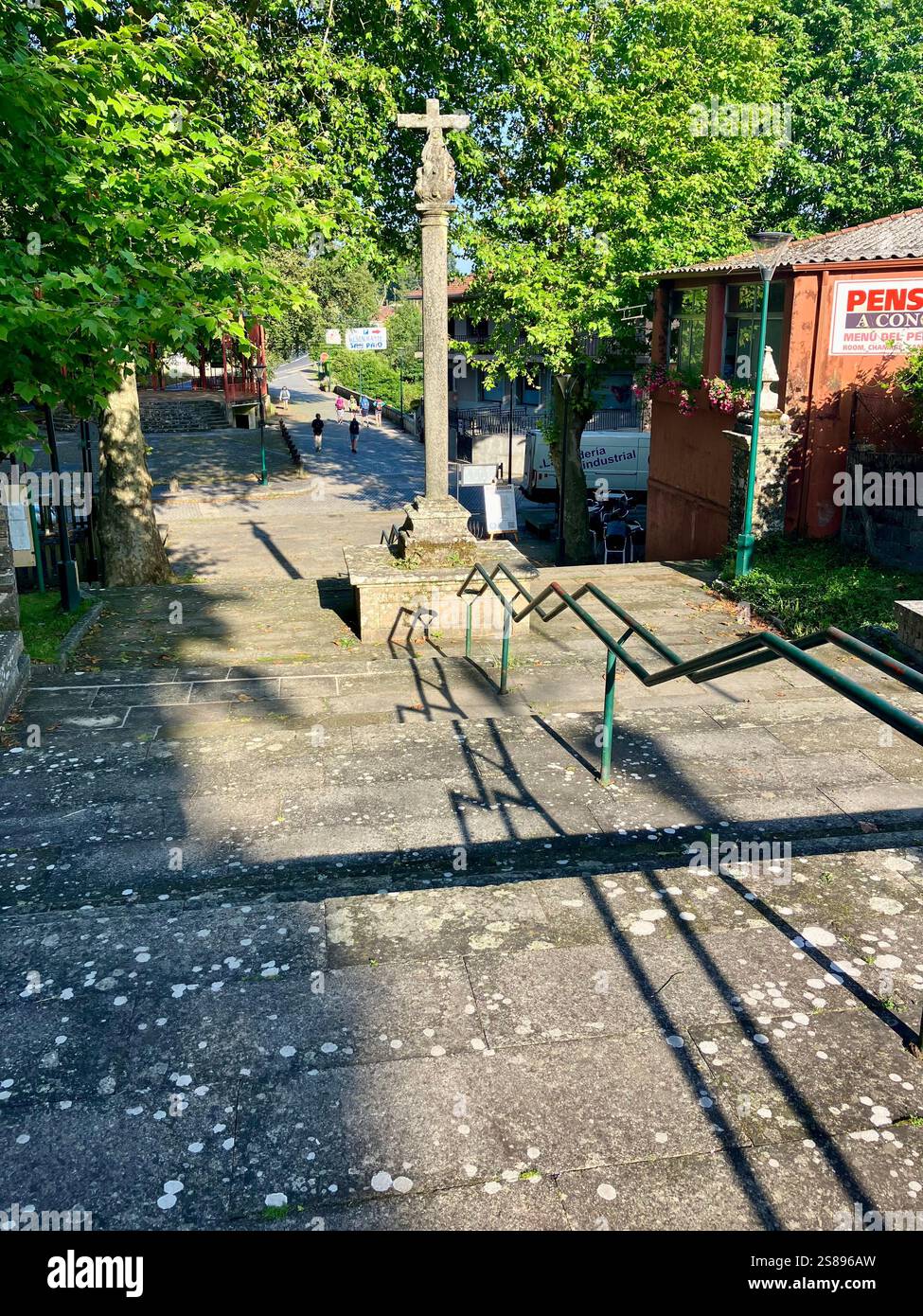 Croci e cartelli sul cammino di Santiago: Pellegrini che attraversano Lavacolla nell'ultima tappa del cammino Frances - Immagine stock catturata con smartphone