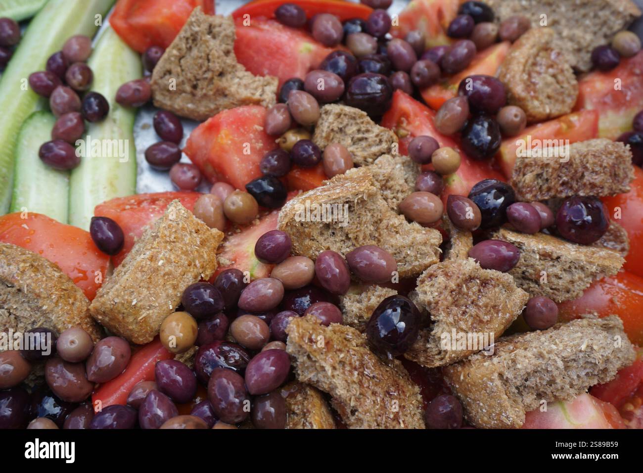 Un'insalata tradizionale greca del villaggio con pomodori, cetrioli, fette cretesi e olive - dieta mediterranea con molti benefici per la salute Foto Stock