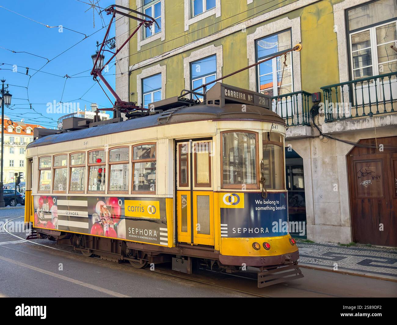 Lisbona, Portogallo, Europa - 13 gennaio 2025: Tram elettrico d'epoca che corre in una delle strade del centro di Lisbona. - Immagine stock catturata con smartphone