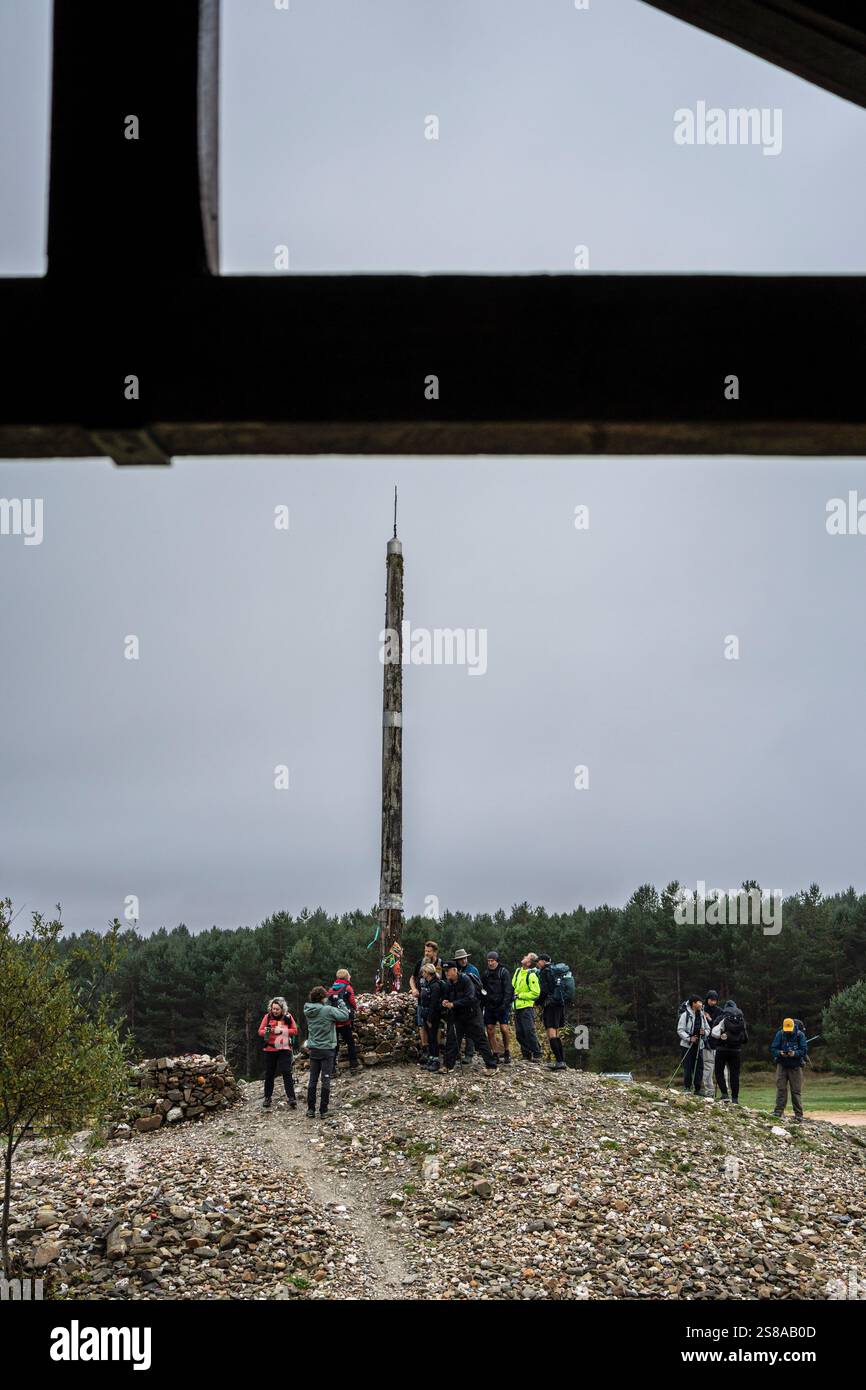 Pellegrini di Santiago a Cruz de ferro (Croce di ferro), collina di Foncebadón, regione di Bierzo, Castiglia e León, Spagna. Foto Stock