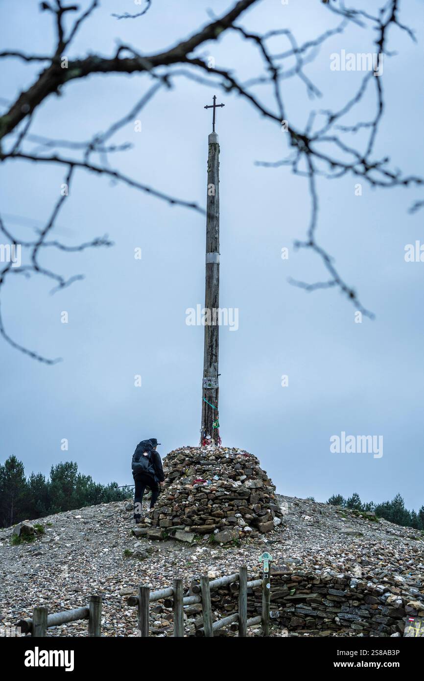 Pellegrini di Santiago a Cruz de ferro (Croce di ferro), collina di Foncebadón, regione di Bierzo, Castiglia e León, Spagna. Foto Stock