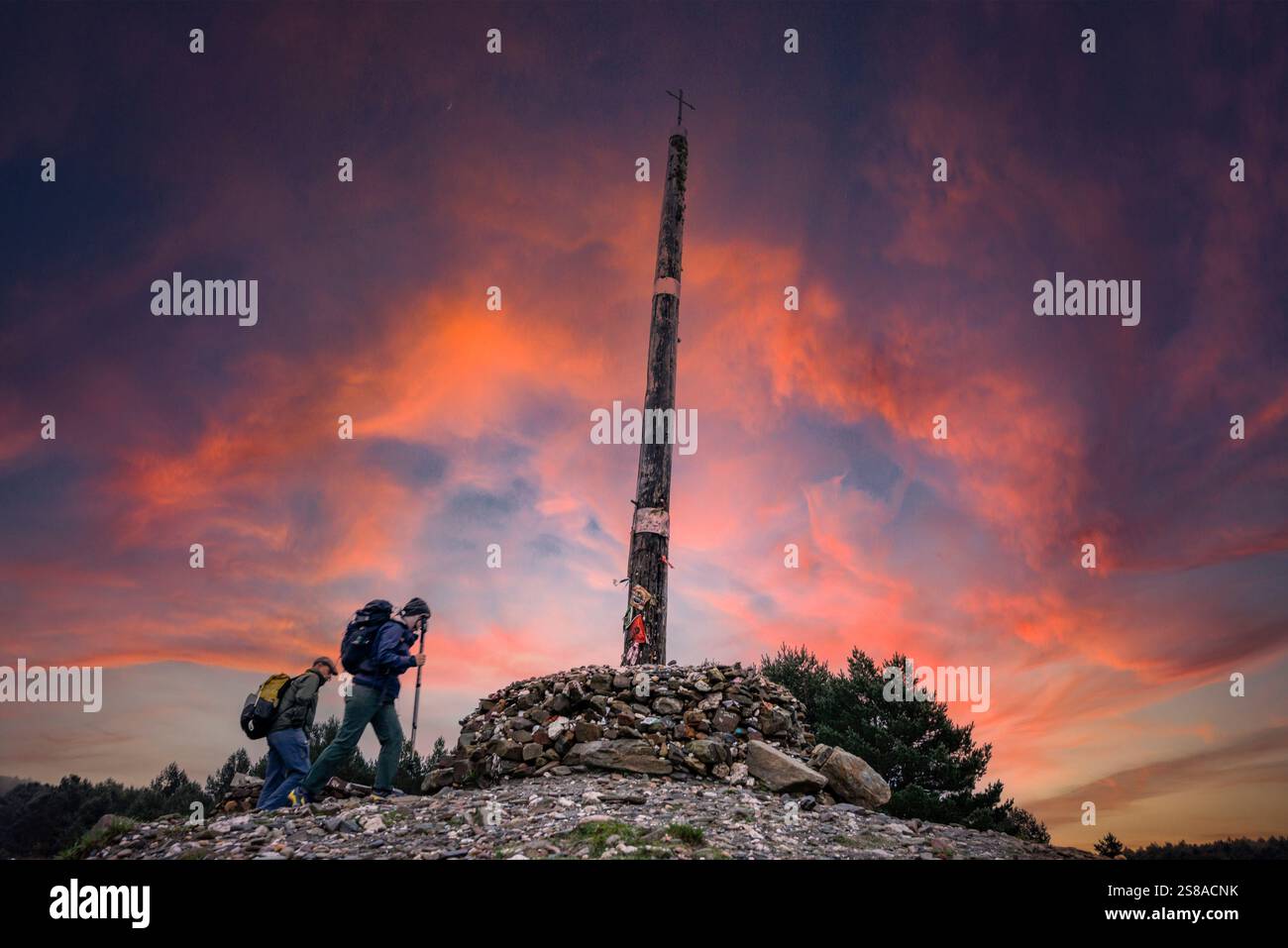 Pellegrini di Santiago a Cruz de ferro (Croce di ferro), collina di Foncebadón, regione di Bierzo, Castiglia e León, Spagna. Foto Stock