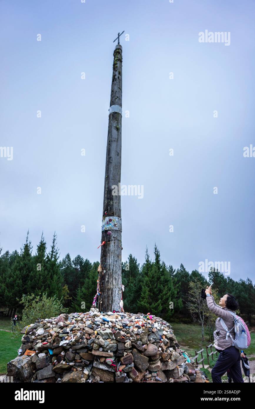 Pellegrini di Santiago a Cruz de ferro (Croce di ferro), collina di Foncebadón, regione di Bierzo, Castiglia e León, Spagna. Foto Stock