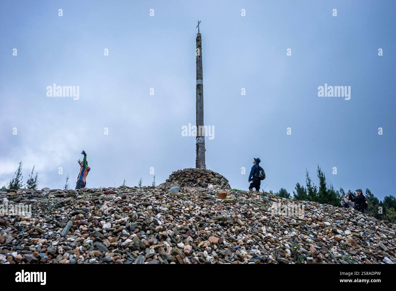 Pellegrini di Santiago a Cruz de ferro (Croce di ferro), collina di Foncebadón, regione di Bierzo, Castiglia e León, Spagna. Foto Stock