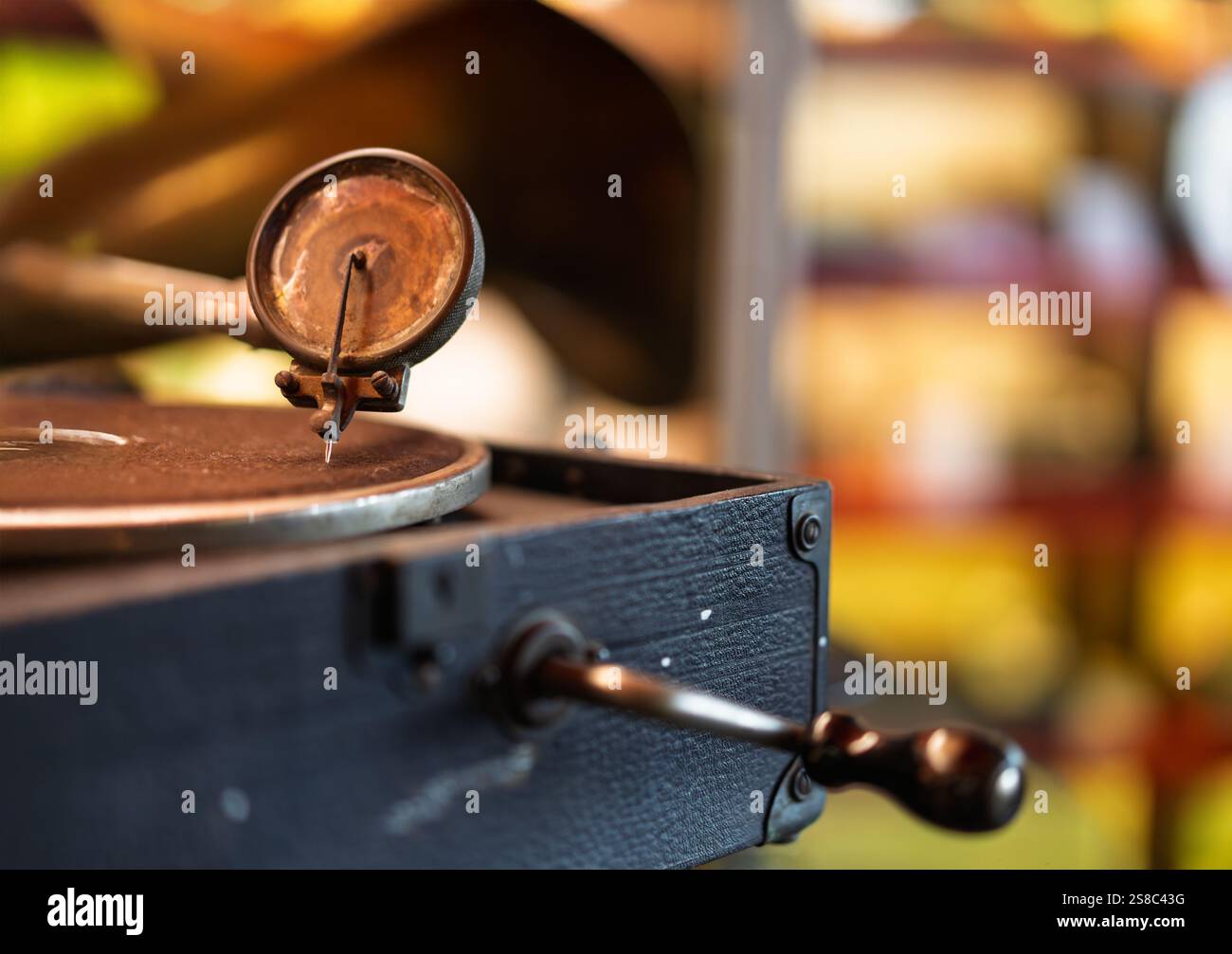 Un dettaglio dettagliato di un ago per fonografo d'epoca e del braccio poggiati su un lettore di dischi con sfondo sfocato Foto Stock