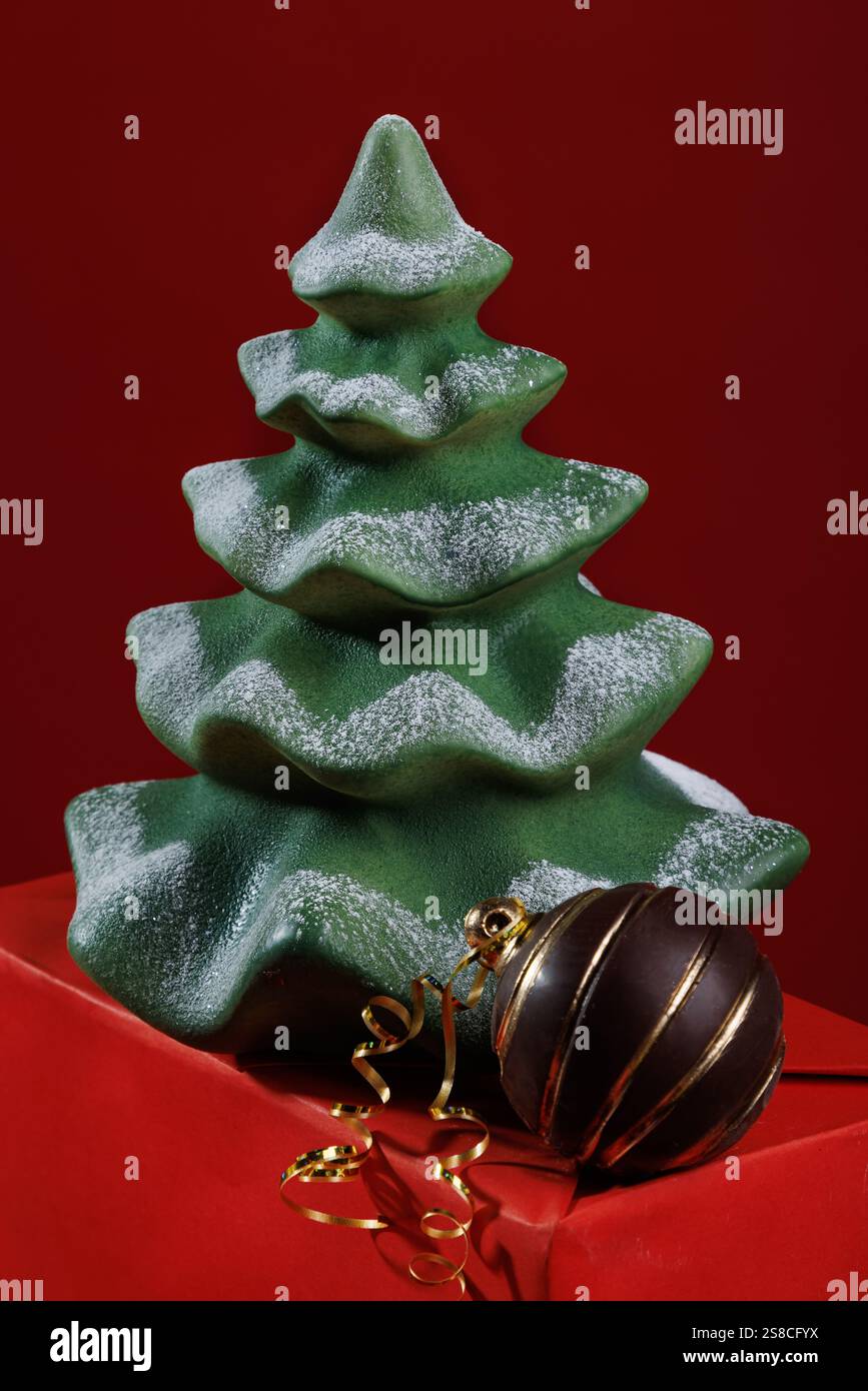 Figure di cioccolato natalizio - albero di Natale e palla di cioccolato su sfondo rosso Foto Stock