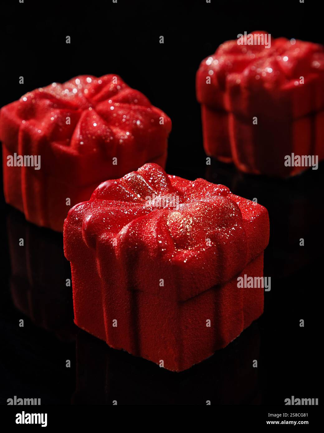 Piccole mousse rosse sotto forma di scatola regalo. Mousse dolci fatti in casa con rivestimento in velluto rosso. Foto Stock