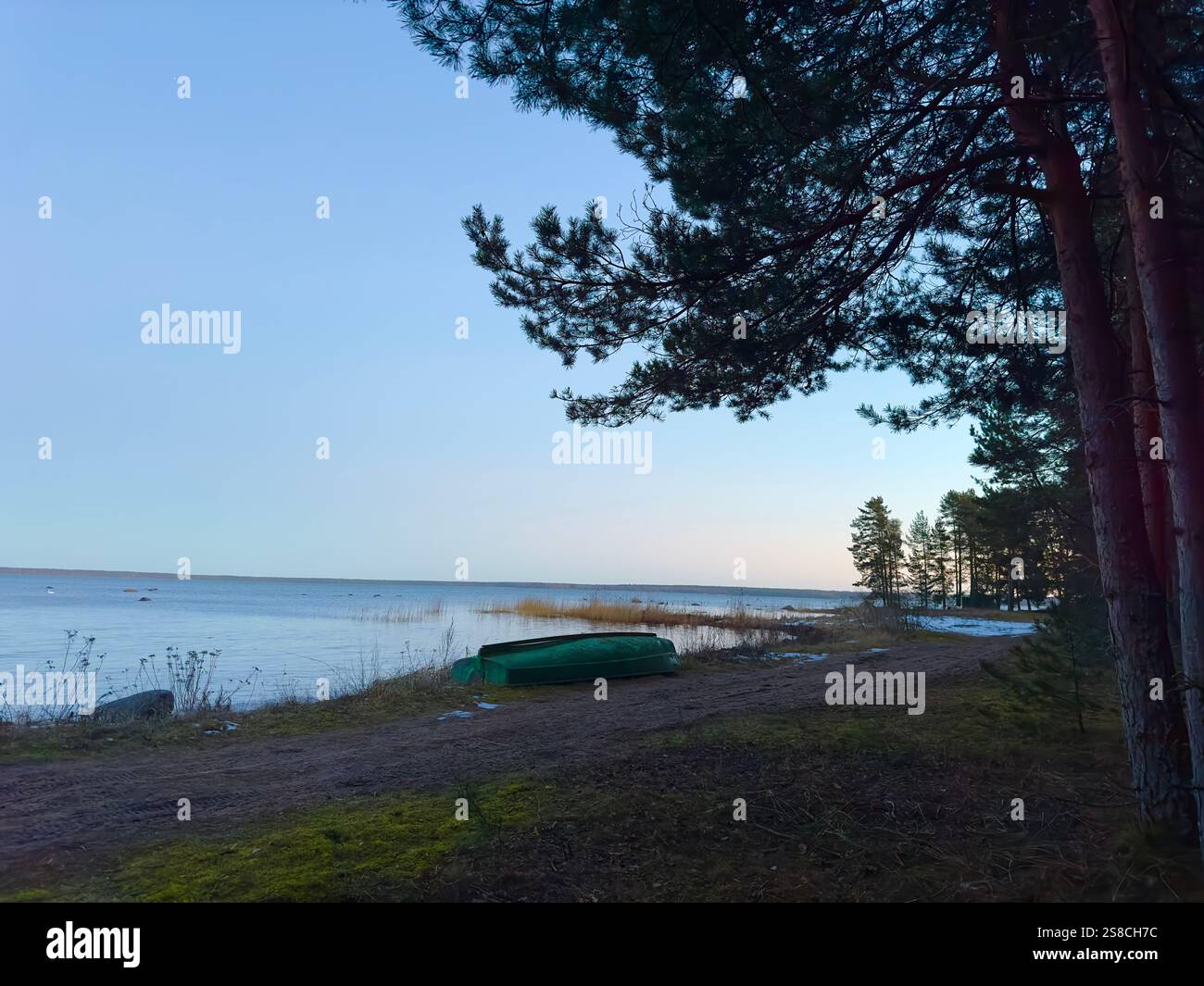Spiaggia in Estonia su una barca verde di un giorno d'inverno su una riva - Immagine stock catturata con smartphone