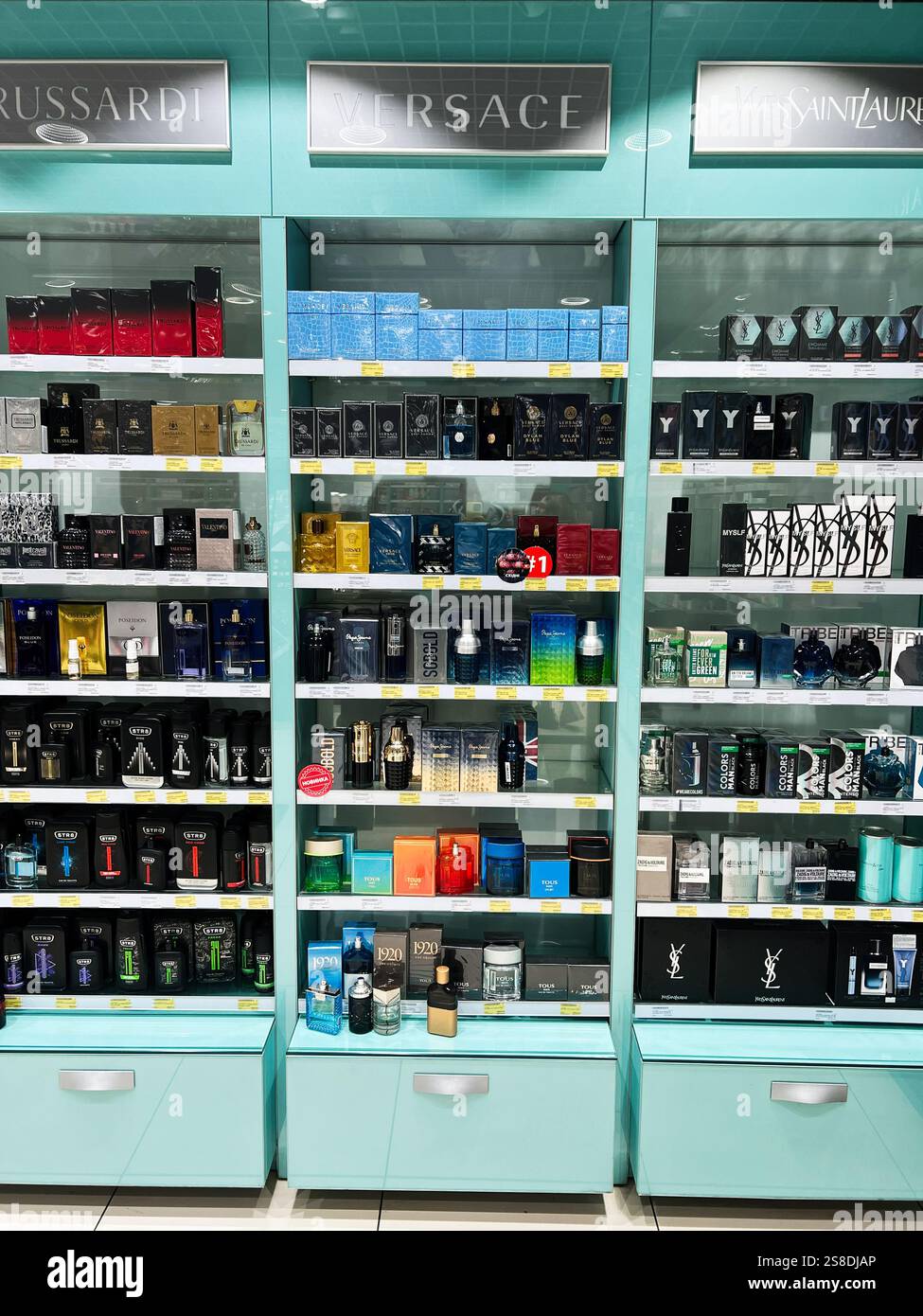 Kiev, Ucraina - 21 gennaio 2025: I lussuosi profumi Versace delle migliori marche sono esposti ordinatamente su scaffali turchesi in un negozio. Foto Stock