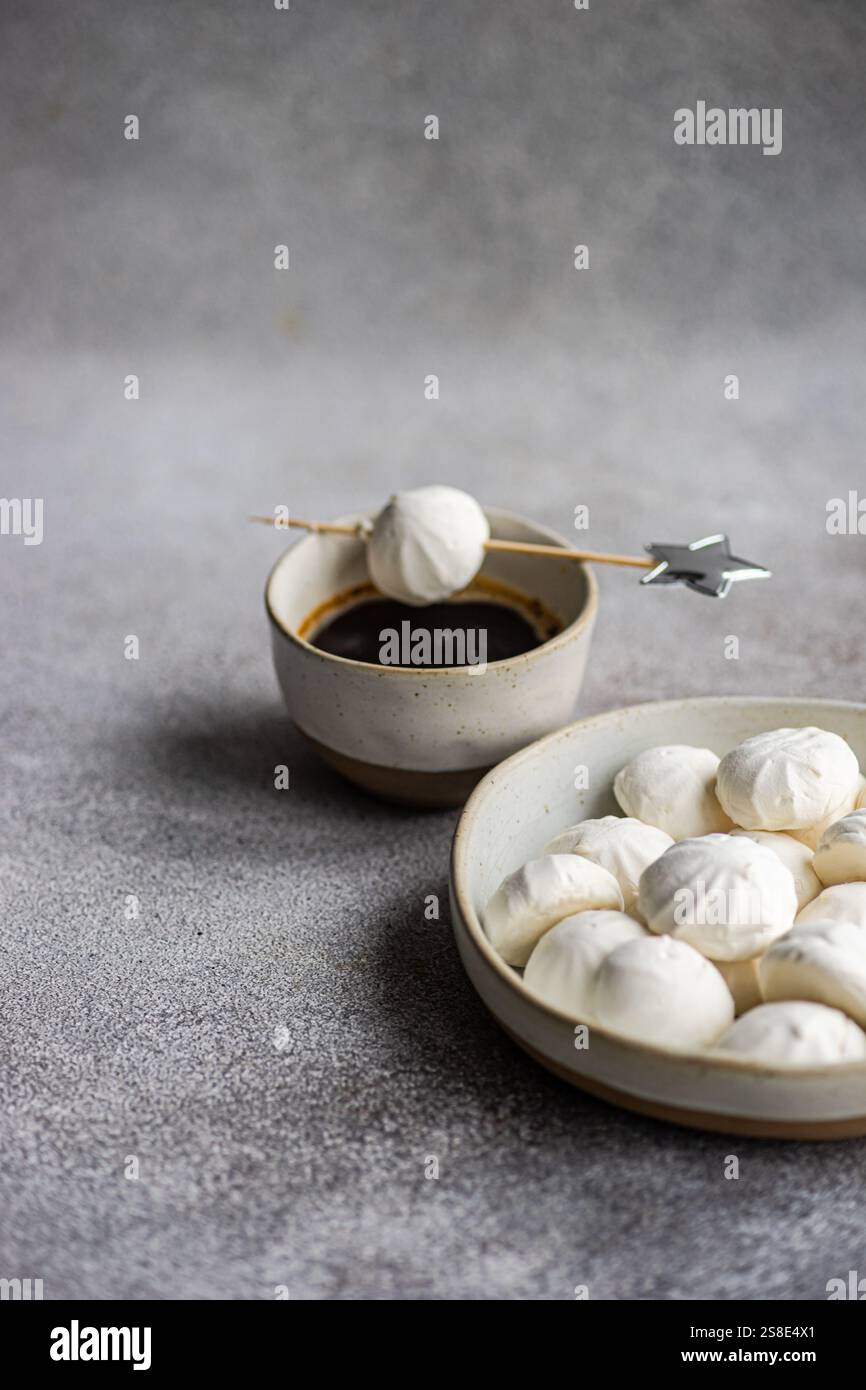 Deliziosi mini marshmallow alla vaniglia fatti in casa ripieni di marmellata di rose, abbinati a una rinfrescante bevanda al liquore al caffè, Una deliziosa e appagante tre Foto Stock