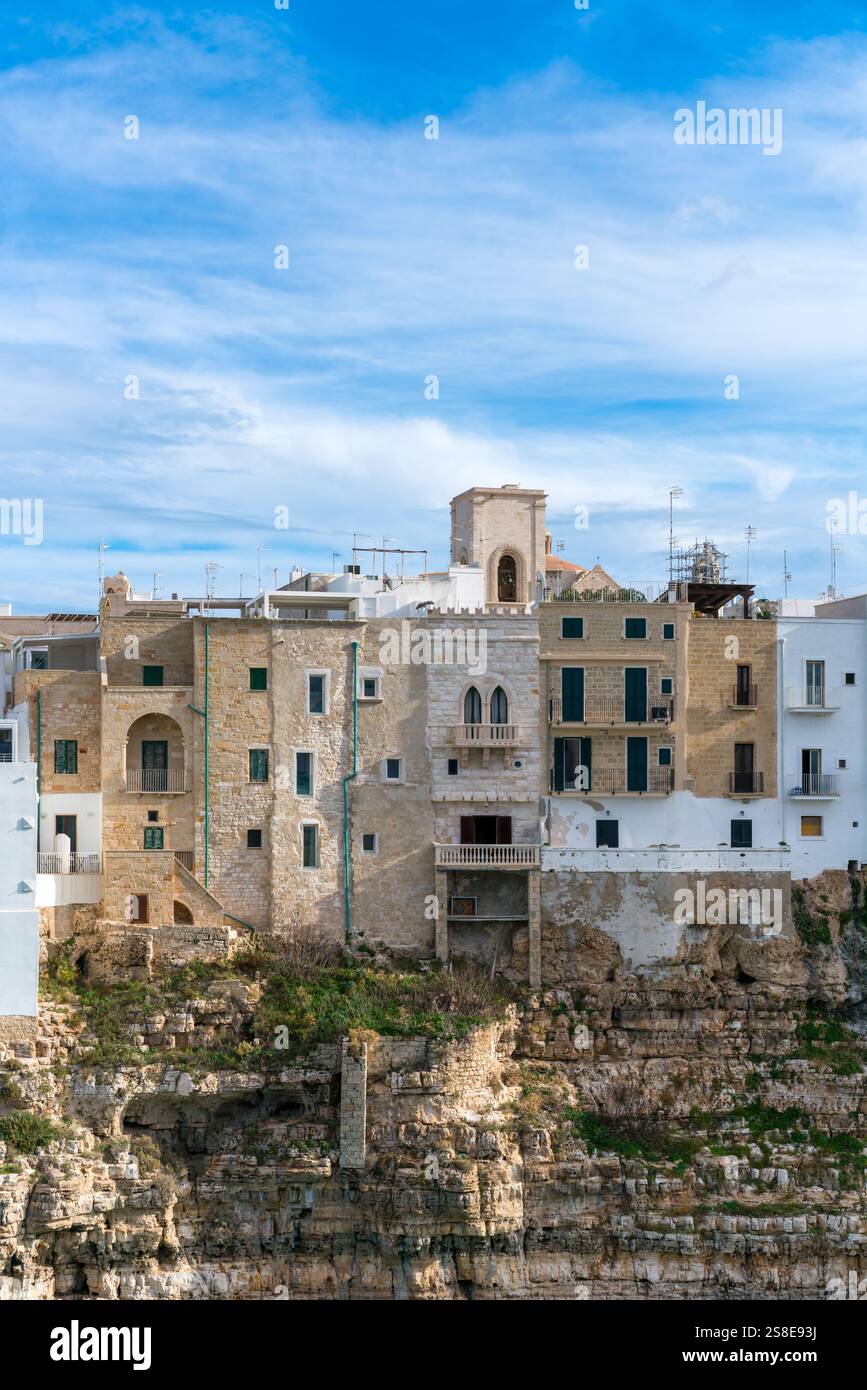 Eleganti case in pietra e imbiancate si trovano in cima alle aspre scogliere di Polignano a Mare, affacciate sul Mare Adriatico, che mostrano il fascino e la storia di Pugl Foto Stock