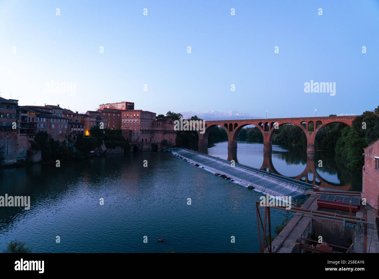 Una serena vista serale del Pont Vieux sul fiume Tarn ad Albi, in Francia, lo storico ponte ad arco e gli edifici in terracotta si riflettono splendidamente nel Foto Stock