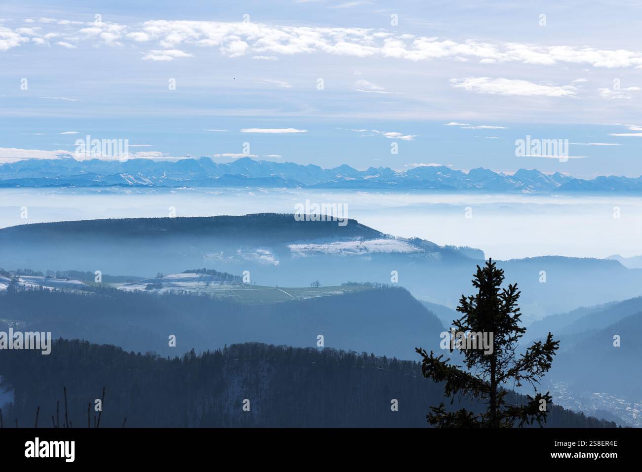 Vista sulle montagne con le Alpi sullo sfondo in una nebbiosa giornata autunnale a Wasserfallen, Baselland, Svizzera Foto Stock
