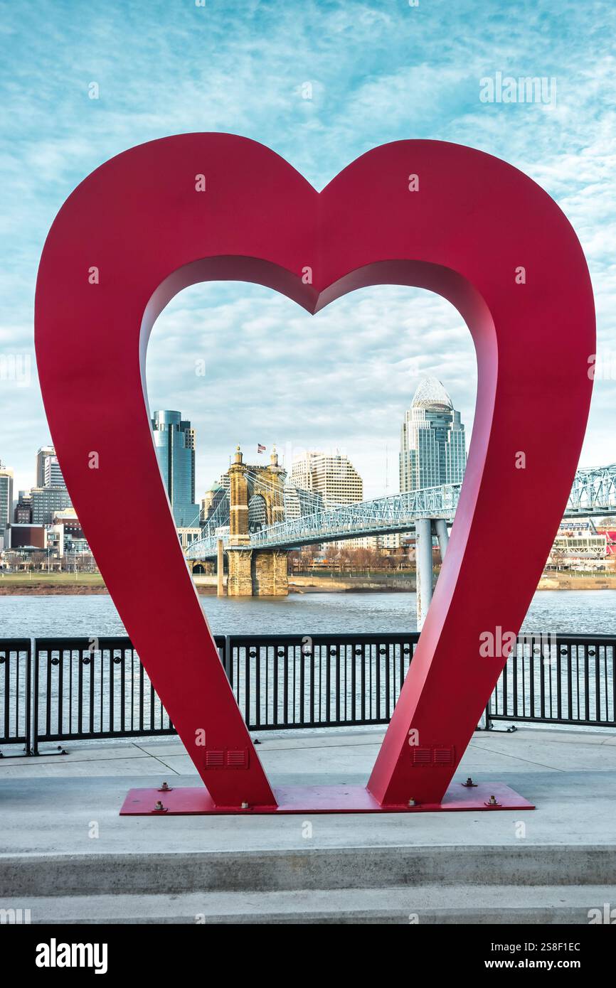 Lo skyline di Cincinnati è visibile attraverso il cuore della scultura "Love the CoV", degli artisti Owens + Crawley, a Covington, Kentucky, USA. Foto Stock