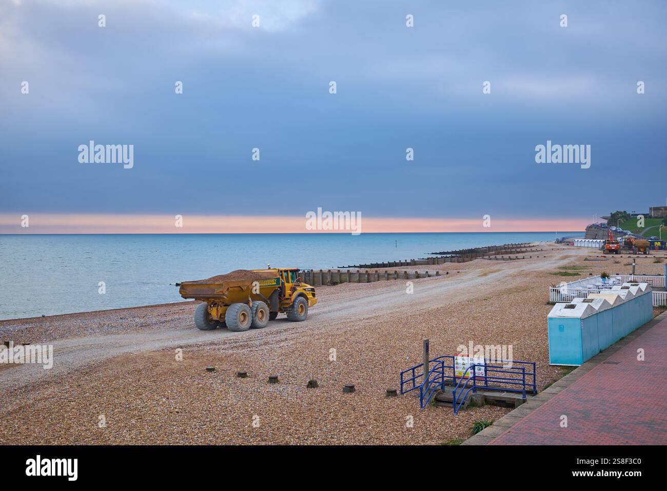 Eastbourne, East Sussex, Regno Unito - 20 gennaio 2025. Un dumper articolato Volvo A30G su una spiaggia di ciottoli contro un cielo grigio e un mare blu. Foto Stock