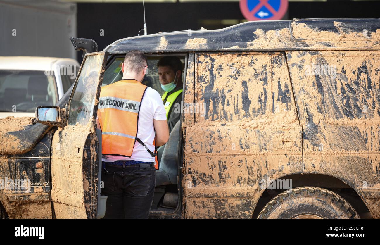 Membri della protezione civile (Protección Civil) e auto fuoristrada ricoperte di fango dopo l'inondazione DANA. Land Rover Discovery. Alfafar, Spagna Foto Stock