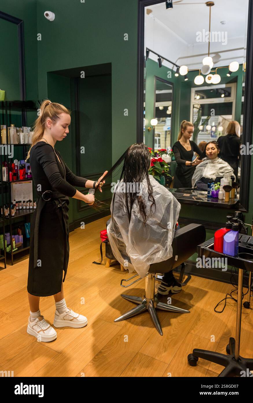 In un salone di bellezza, una ragazza cliente si sta preparando e tagliando i capelli Foto Stock