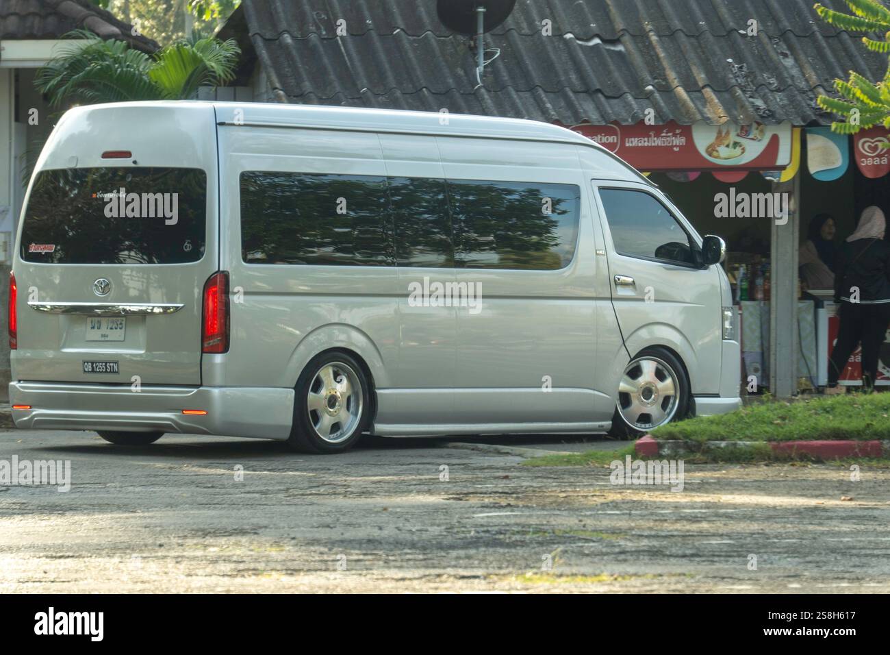 Bangkok, tailandia - dicembre 25 2024: Furgone personalizzato in argento parcheggiato fuori da un piccolo negozio in una posizione tropicale durante il giorno Foto Stock