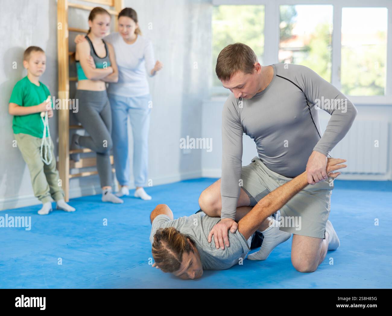 L'uomo in palestra esegue elementi di base del sistema di autodifesa krav maga. Foto Stock