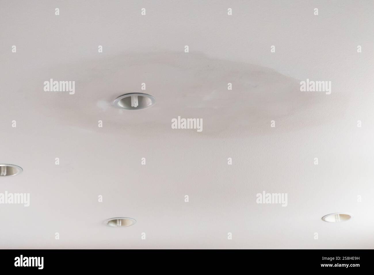 Danni alla parete a secco del soffitto dopo una perdita dal tetto Foto Stock