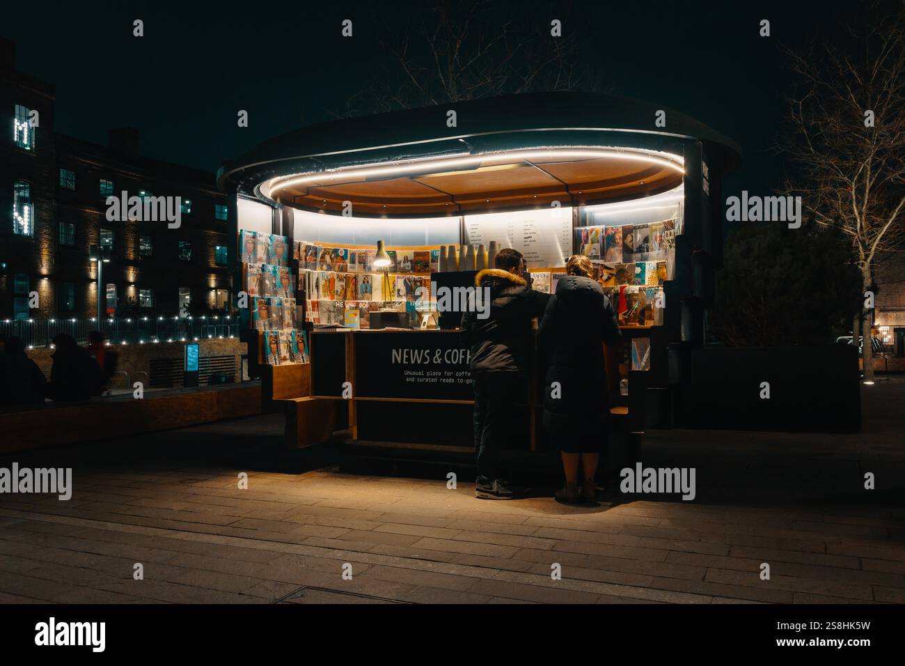 Edicola Cosy Night Time che vende riviste e caffè nell'ambiente urbano di Kings Cross, Londra Foto Stock