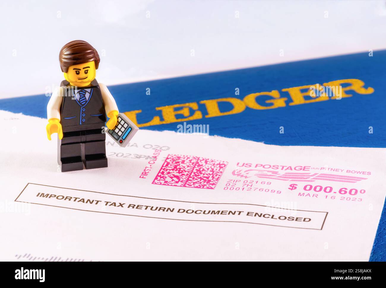 Chappaqua, NY - 11 aprile 2024: Income Tax Day Concept Lego minifigure accountant with ledger book and IRS envelope marked important tax Information Foto Stock